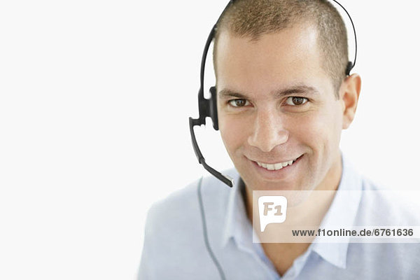 South Africa  Portrait of smiling young man wearing headset  studio shot