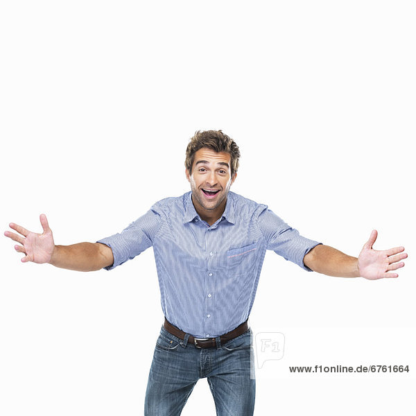 Studio shot of young cheerful man with arms outstretched