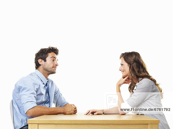 Uninterested business man and smiling business woman sitting at table for date