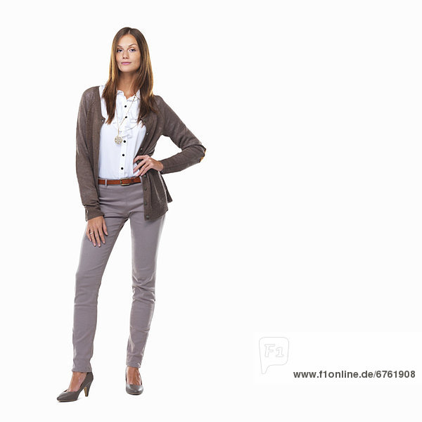 Studio shot of attractive sarcastic business woman standing with hand on hip