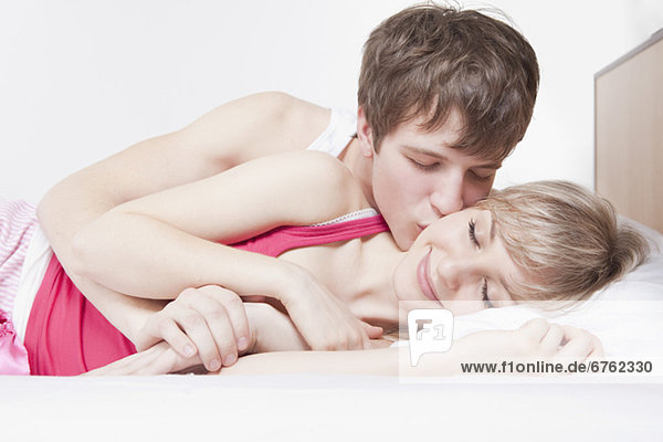 Man kissing woman in bed