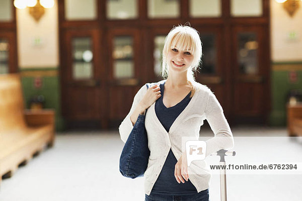 USA  Seattle  Young woman at train station standing with luggage and looking at camera