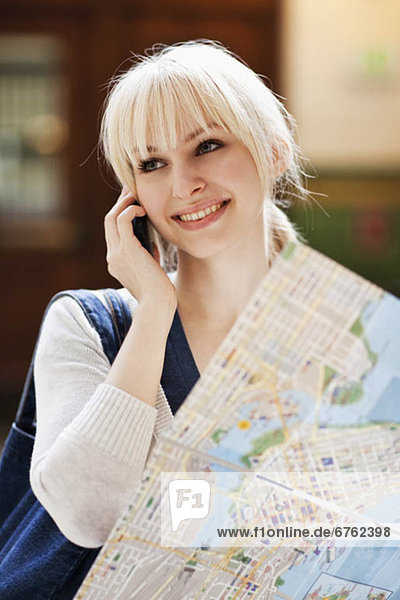 USA  Seattle  Young woman talking via phone and holding map