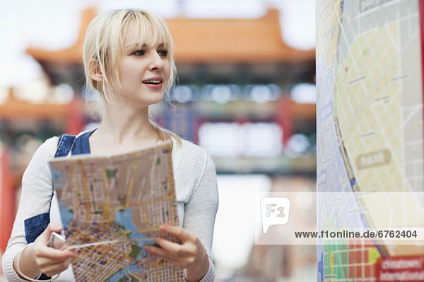 USA  Seattle  Smiling young woman holding map