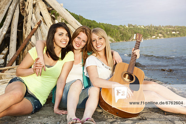 Portrait of three young women hanging out on beach