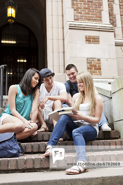 Four college students sitting on steps