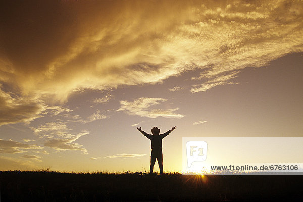Man viewing Sunset with Arms Outstretched  Manitoba