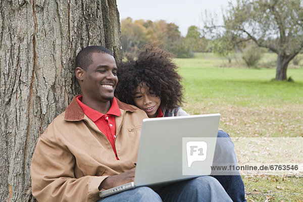 Couple looking at laptop outside