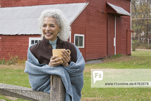 Woman holding mug outside