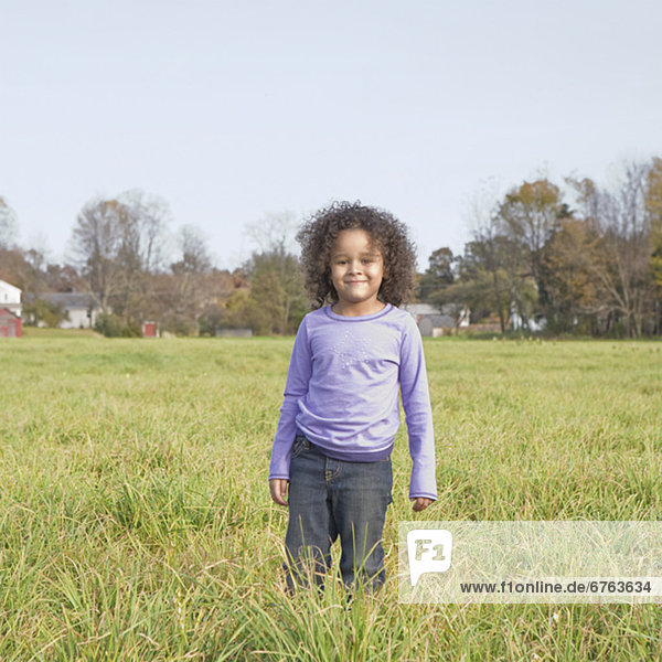 Young girl standing in meadow