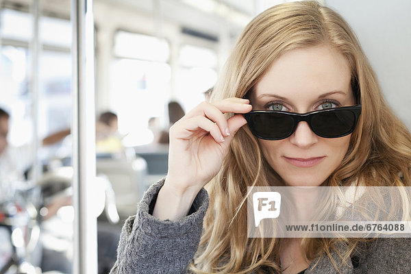 Portrait of woman wearing sunglasses in subway train
