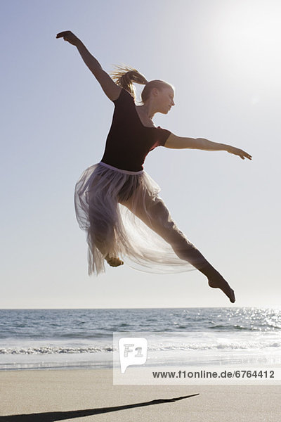 Dancer leaping on beach