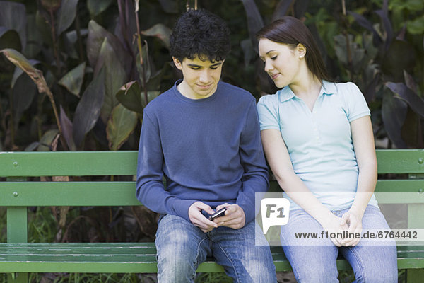 Young couple sitting on park bench
