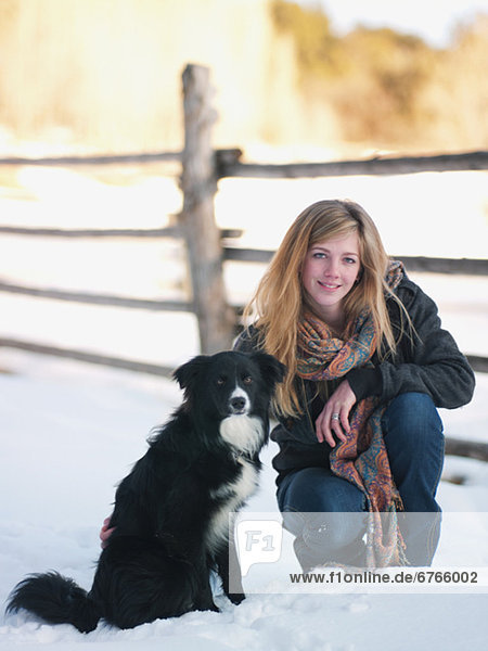 Young woman with dog on ranch