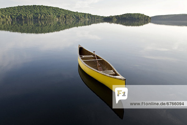 Yellow canoe floating on Smoke Lake  Algonquin Park  Ontario