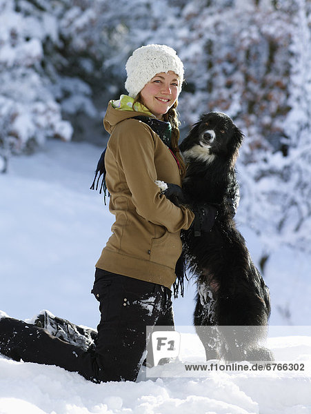 USA  Colorado  portrait of young woman with dog in snow