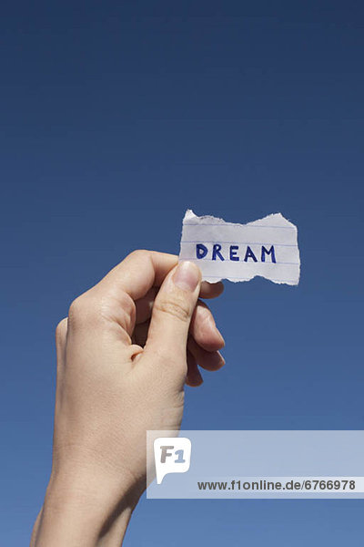 'USA  Arizona  Winslow  Human hand holding paper with ''dream'' text on it'