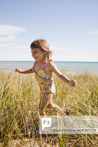 Beaver Island  Girl running in grass on beach  Beaver Island  Michigan  USA