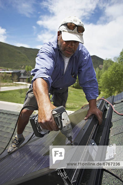 Dach bauen arbeiten installieren Sonnenkollektor Sonnenenergie Tisch