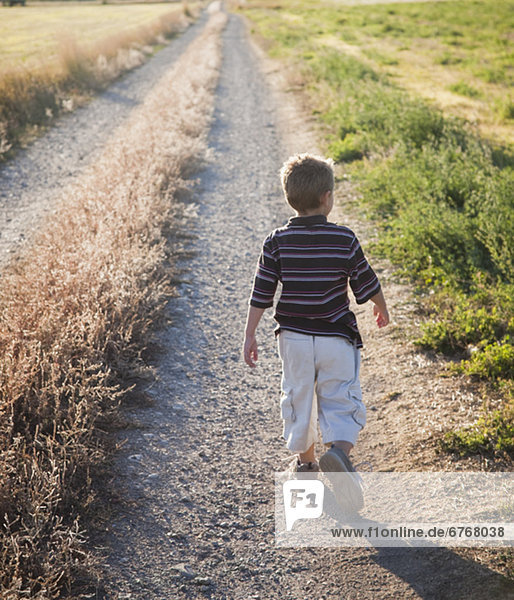 Young boy walking on rural path
