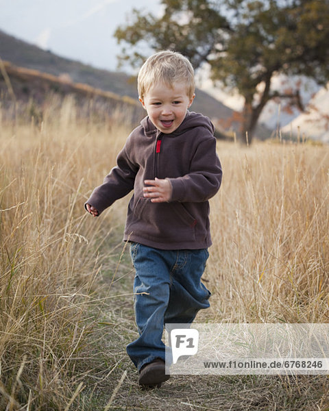 Boy running in meadow
