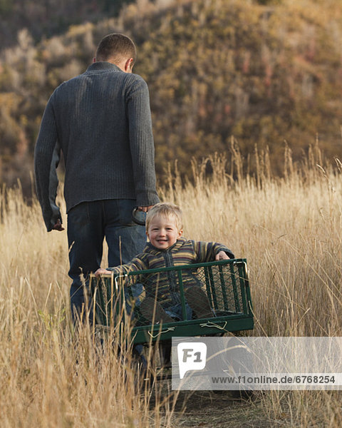 Father pulling son in wagon
