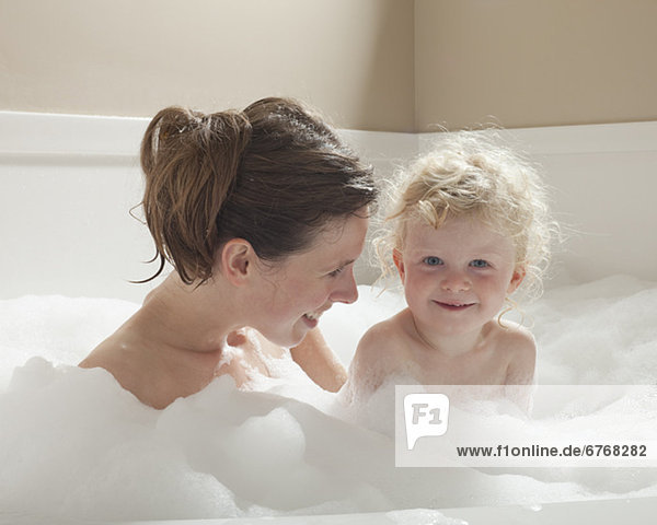 Mother and child having bubble bath