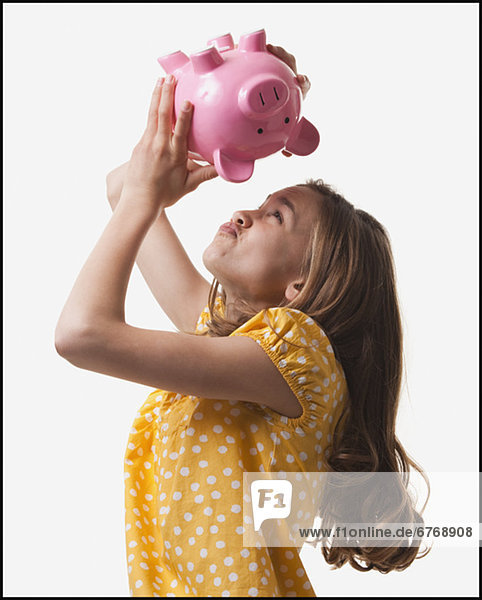 Teenage girl trying to get money out of piggy bank