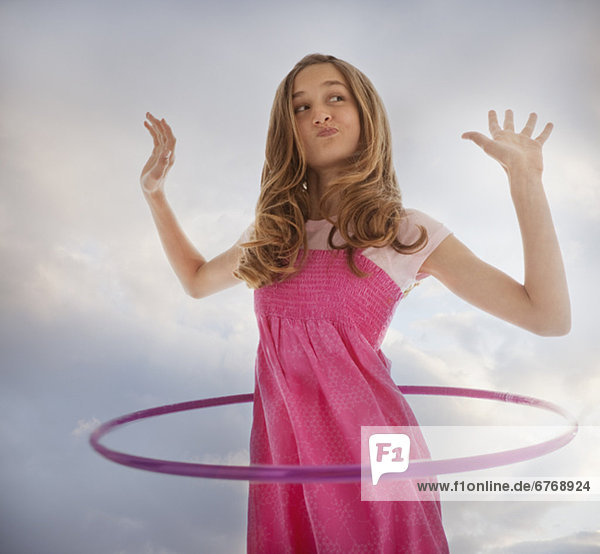 Teenage girl playing with a hula hoop