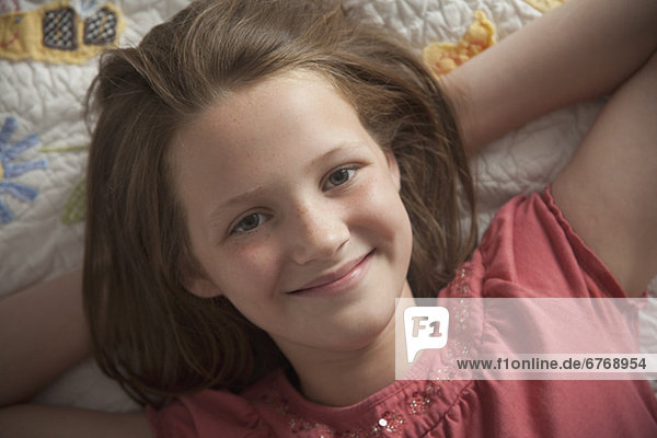 Young girl relaxing on her bed
