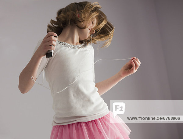 Young girl dancing on her bed