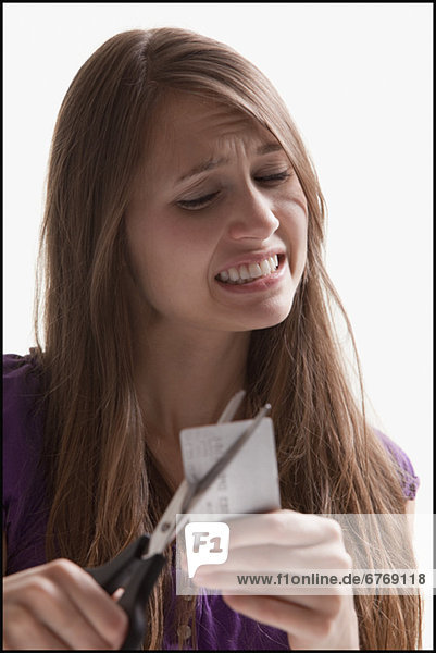 Woman reluctantly cutting her credit card