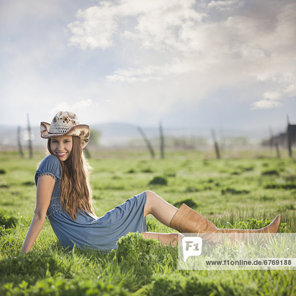Cowgirl relaxing in field