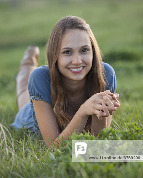 Beautiful long haired woman relaxing on the grass