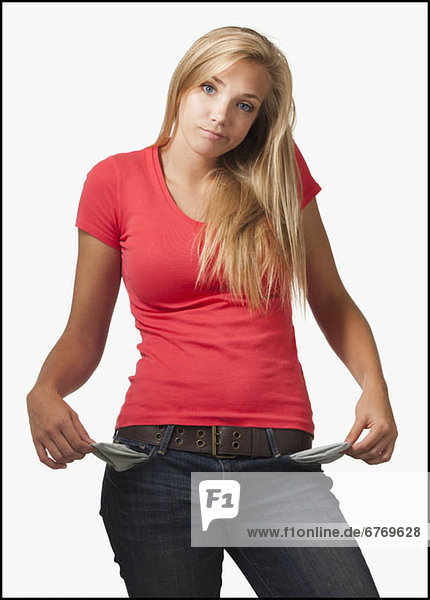 Young woman on white background showing empty pockets
