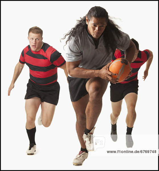 Rugby player running with ball  team chasing