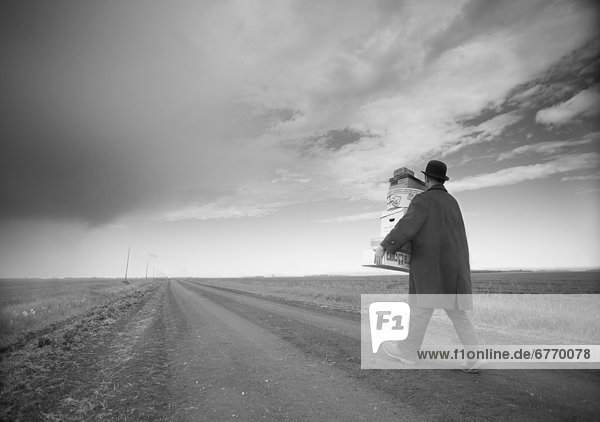 Man in Coat and Hat Carrying Boxes on Country Road  Winnipeg  Manitoba