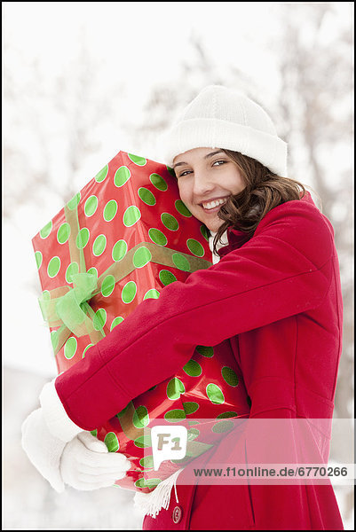 Vereinigte Staaten von Amerika USA Außenaufnahme junge Frau junge Frauen Portrait umarmen Weihnachtsgeschenk freie Natur