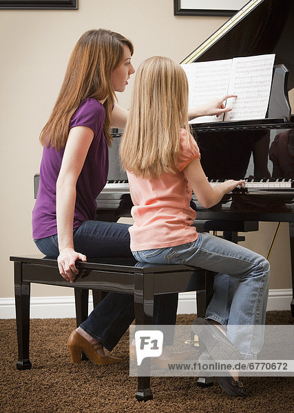 USA  Utah  Lehi  Girl (8-9) and mother playing grand piano