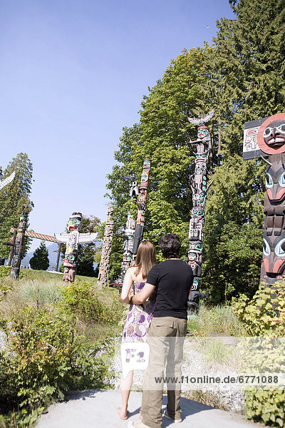 Couple looking at totem poles  Stanley Park  Vancouver  British Columbia