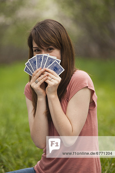 Young woman playing cards in orchard