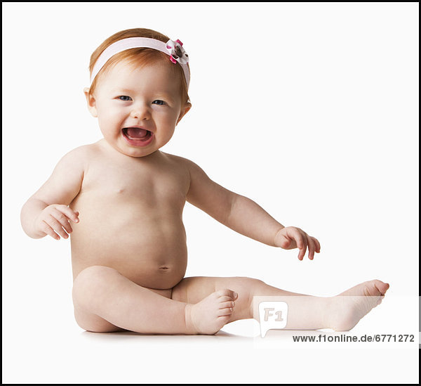 Portrait of baby girl (6-11 months) laughing  studio shot