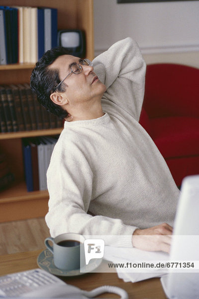 Man stretching at desk