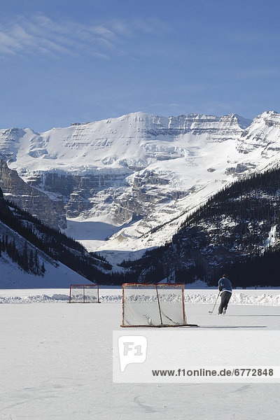Hockey player practicing on Lake Louise  Banff National Park  Alberta