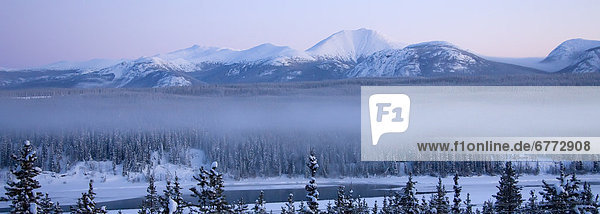 Sunrise over the Teslin River with the mountains of the South Canol Road to the north of it  Yukon