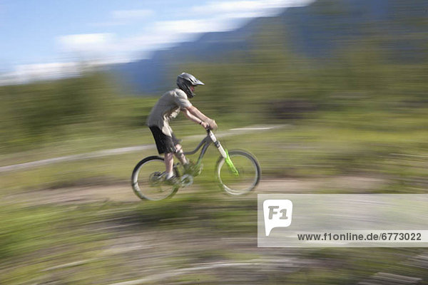 Canada  British Columbia  Fernie  Young man riding on mountain bike