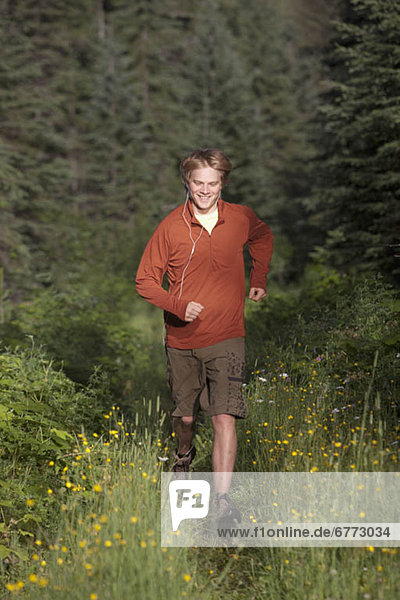 Canada  British Columbia  Fernie  young man jogging in forest