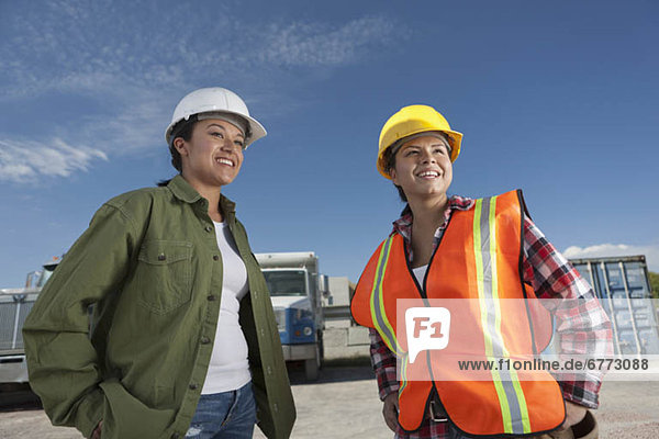Portrait of two female construction workers on building site