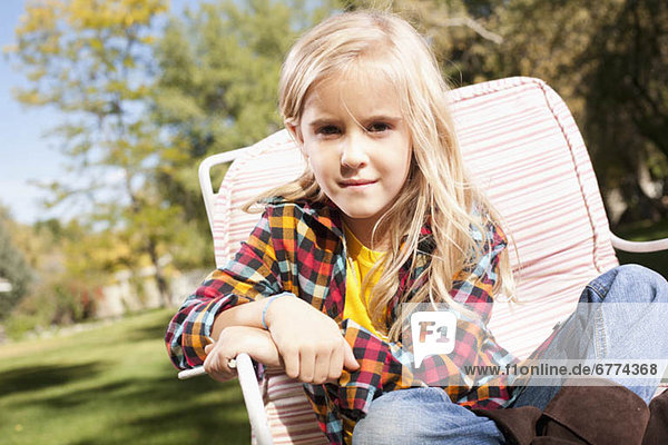 USA  Utah  outdoor portrait of blonde girl (6-7) sitting on deck chair