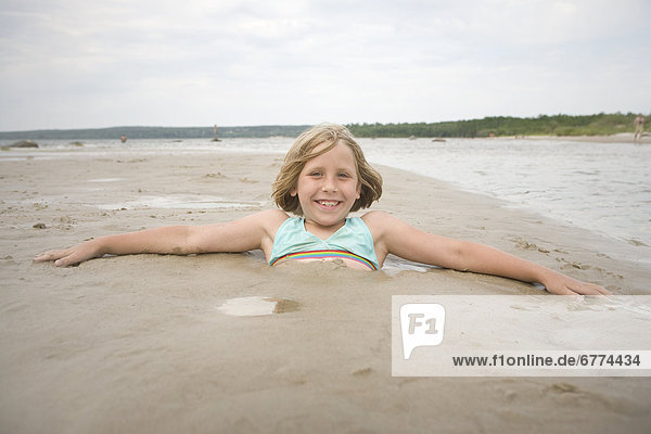Portrait of a girl buried in sand  Grand Beach  Manitoba